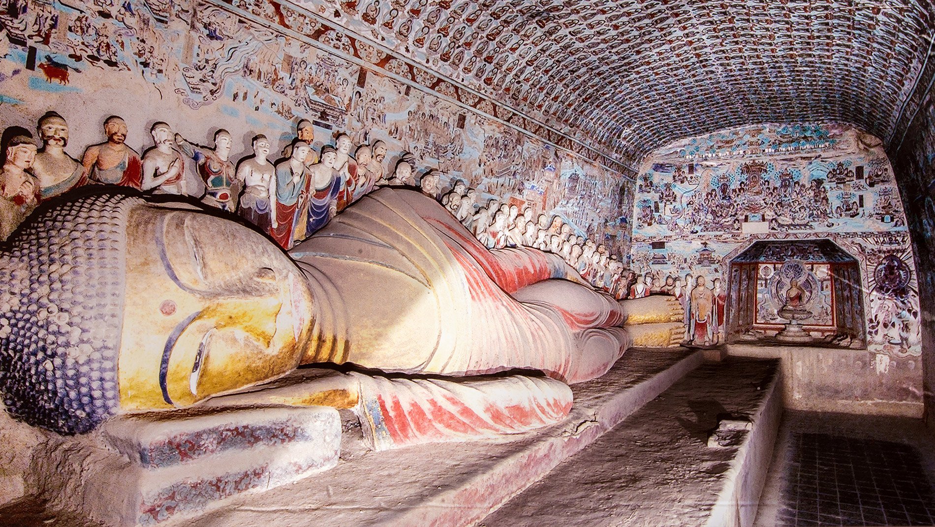 Mogao Caves~The caves span a millennium of history during which time architecture, styles, subjects and painting techniques all evolved. This cave dates from the high Tang period (705 - 781), and features a reclining Buddha.