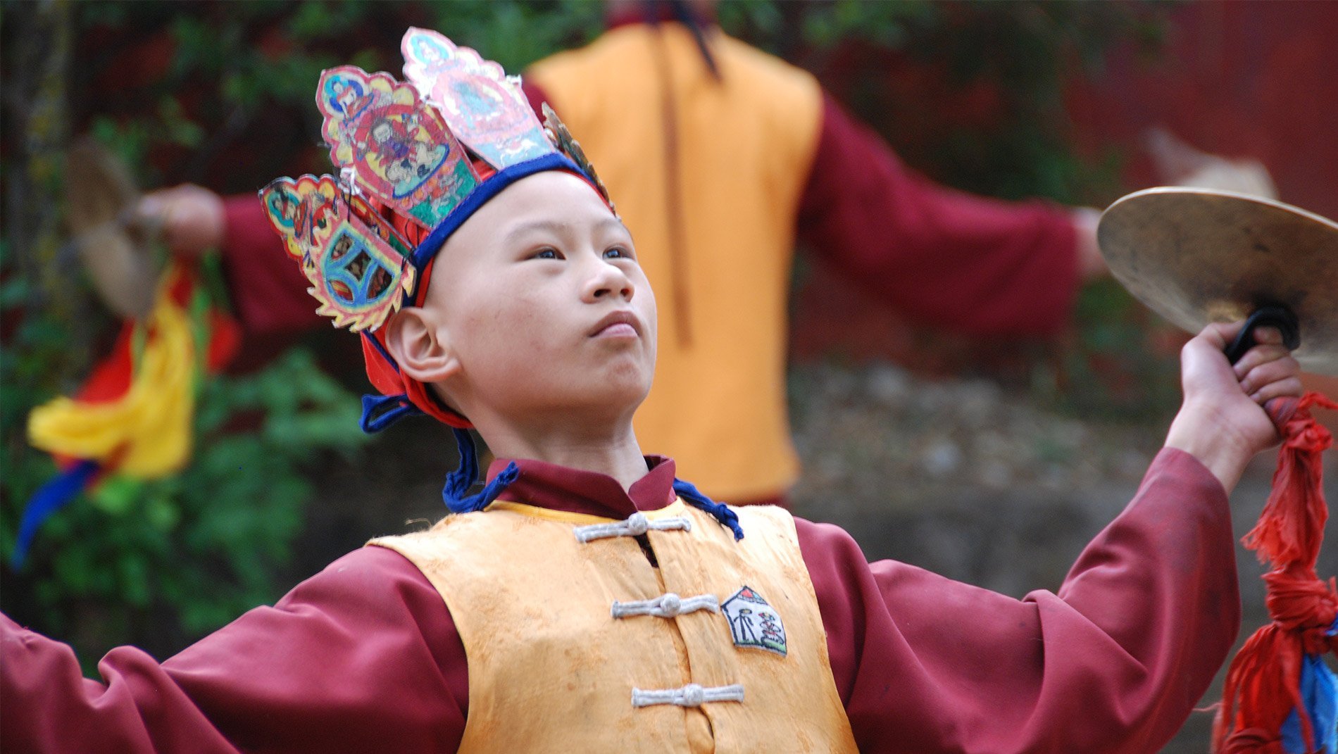 Dongba (Shaman)~Dongba, translated into English as shaman, come in many forms. Though some claim to access the spirit world, this young boy is at a seminary studying how to perform the official functions (e.g. births, deaths & marriages) of a religious functionary.